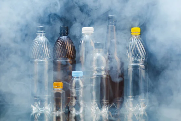 Variedad de botellas de plástico en el humo, concepto de contaminación —  Fotos de Stock