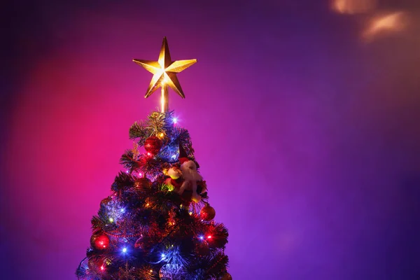 Árbol de Navidad con estrella festiva, fondo púrpura —  Fotos de Stock