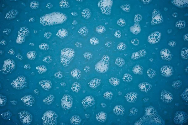 Manchas de espuma en agua azul — Foto de Stock