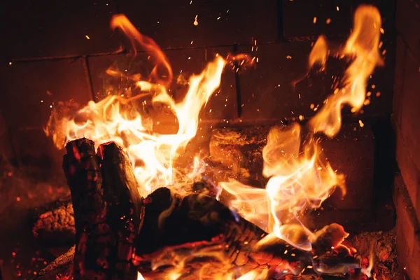 Brandende vuur logs met vonken in de open haard — Stockfoto