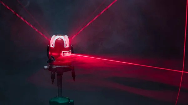 Outil de niveau laser faisceaux de lumière rouge en fumée — Photo