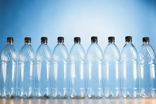 Empty plastic bottles on blue background — Stock Photo, Image