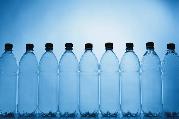 Leere Silhouetten von Plastikflaschen auf blauem Hintergrund — Stockfoto