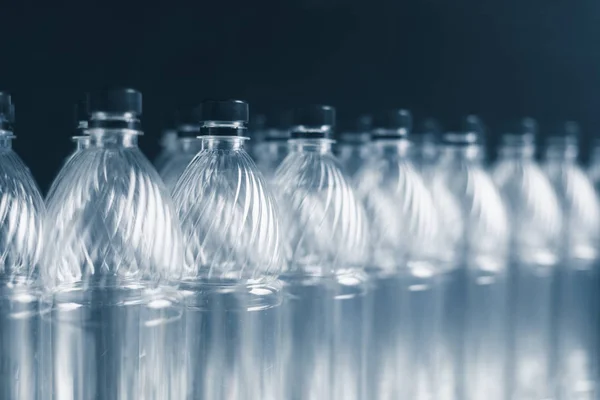 Порожні пластикові пляшки на темному фоні — стокове фото