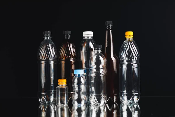 Variété de bouteilles en plastique sur fond noir — Photo