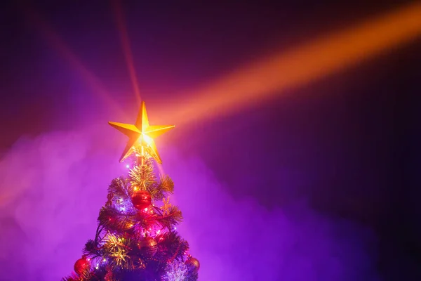 Albero di Natale con luci festive, sfondo viola con fumo — Foto Stock