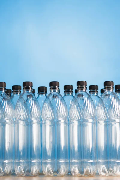 Üres műanyag palackok kék háttérrel — Stock Fotó