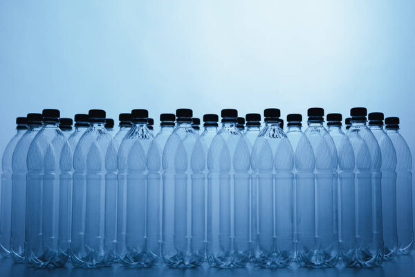 пустые силуэты пластиковых бутылок на синем фоне
