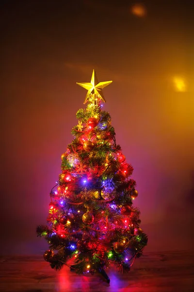 Árbol de Navidad con luces festivas, fondo naranja — Foto de Stock