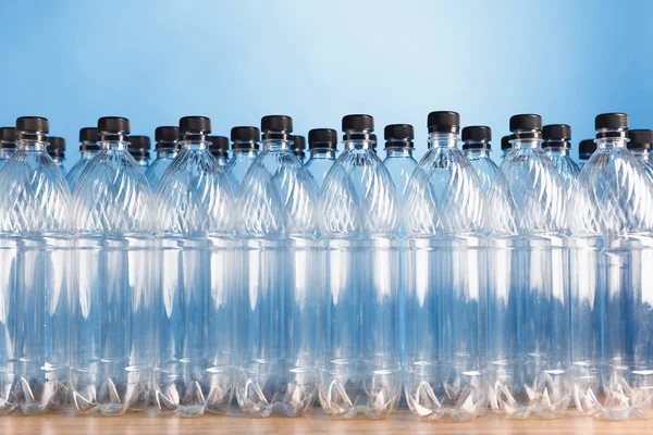 Puste plastikowe butelki na niebieskim tle — Zdjęcie stockowe