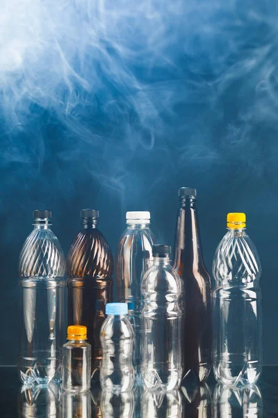 stock image variety of plastic bottles in smoke, pollution concept