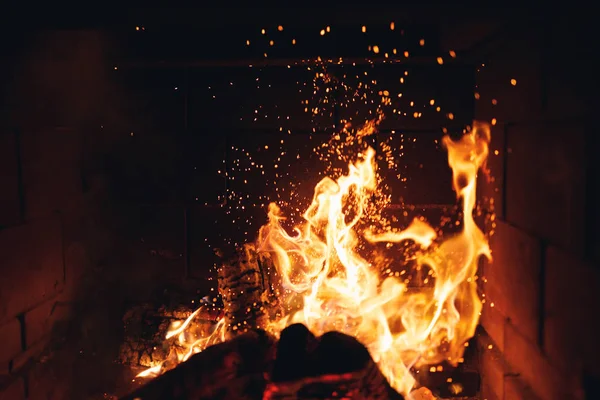 Grumes de feu brûlant avec des étincelles dans la cheminée — Photo