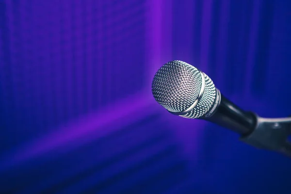 展台上的麦克风,带声学泡沫墙的紫色背景 — 图库照片