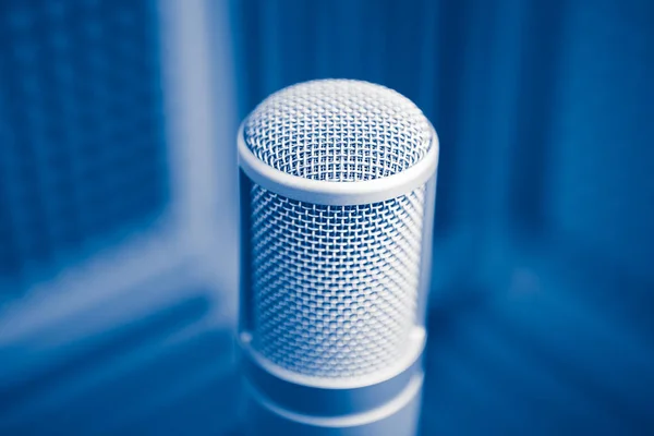 Professionele microfoon in geluidsopnamestudio, blauwe akoestische schuim achtergrond — Stockfoto