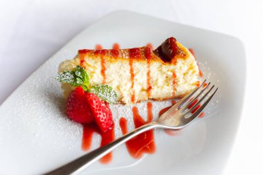 Beyaz tabakta çilekli cheesecake.