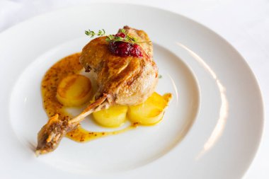 roasted duck leg with potato and orange sauce clipart