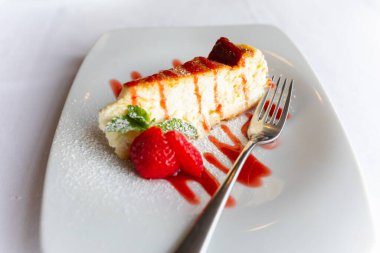 Beyaz tabakta çilekli cheesecake.