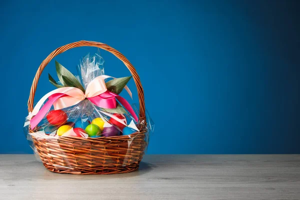 Pasen Geschenkmand Met Veelkleurige Eieren Blauwe Achtergrond — Stockfoto