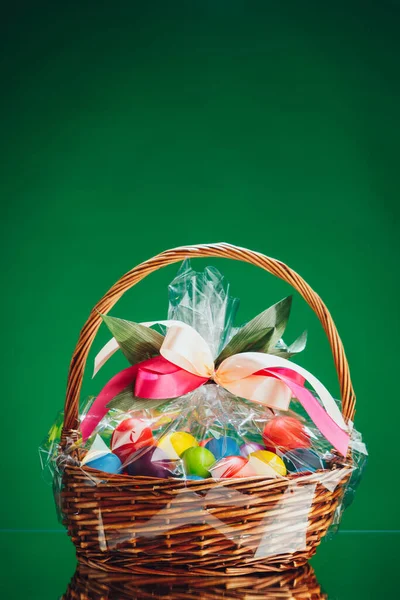 Húsvéti Ajándékkosár Többszínű Tojással Zöld Háttérrel — Stock Fotó