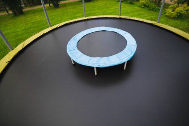 small trampoline on big one with round mat, size comparison, green lawn background clipart