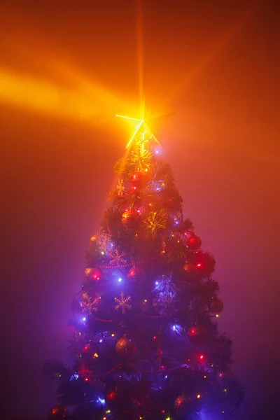 Kerstboom Met Feestelijke Lichtjes Oranje Achtergrond Met Mist — Stockfoto