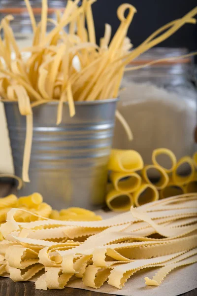 Assortment of homemade fresh egg pasta with a blackboard background