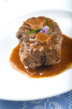 Onun sos ile ve biberiye çiçeklerle süslenmiş kuyruklu güveç