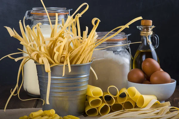 Assortment of homemade fresh egg pasta with a blackboard background