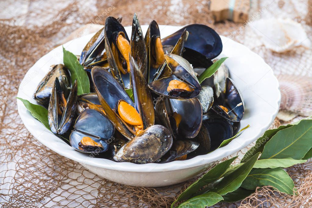 Steamed mussels with lemon and parsley on the table