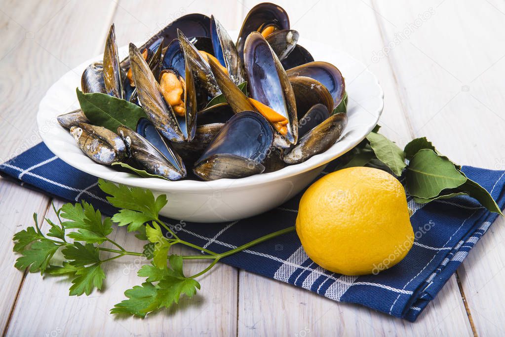 Steamed mussels with lemon and parsley on the table