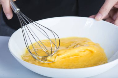Tavuk yumurta bir kase yenerek Şef bir el ile bir mikser