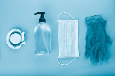 Mavi arkaplandaki kovid 19 koronavirüsten korunmak için hidroalkolik jel ve sabunla maskelenmiş.