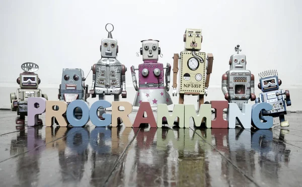 Das Wort Programmierung Mit Holzbuchstaben Und Retro Spielzeugrobotern Auf Einem — Stockfoto