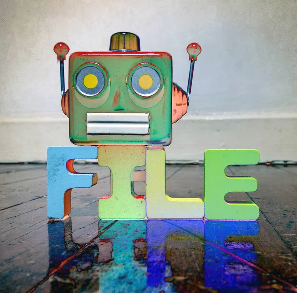 red retro robot head on the word FILE  on old wooden floor