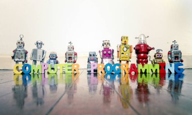  Tamamlayıcı Program Ahşap harfler ve yansımalı ahşap zeminde eski robot oyuncaklar