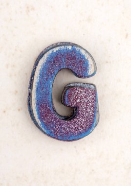 eski boyalı ahşap harf G s eski yıpranmış kağıt üzerinde bir yığın