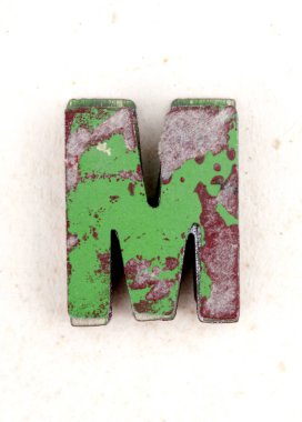 eski boyalı ahşap harf M, s eski yıpranmış kağıt üzerinde bir yığın