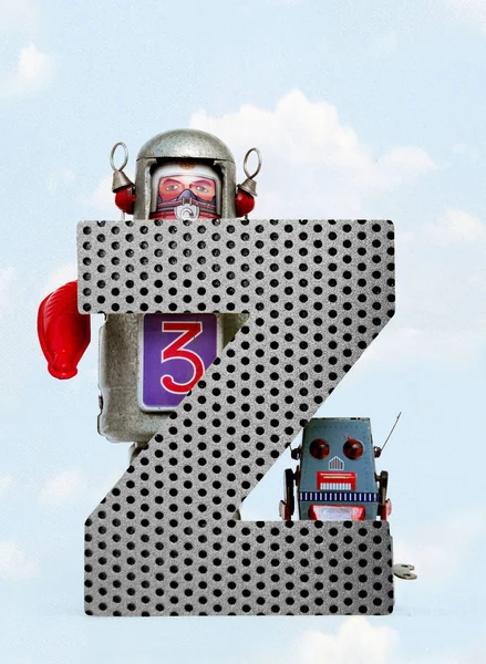 Retro robots holding a big  metal letter  Z with blue sky — Stock Photo, Image