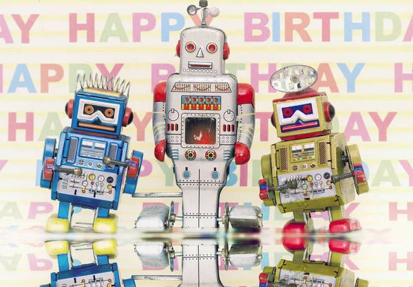 Drei Retro-Bots mit Happy Birthday Hintergrund — Stockfoto