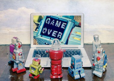 retro robot oyuncaklar bir dizüstü bilgisayar etrafında toplamak