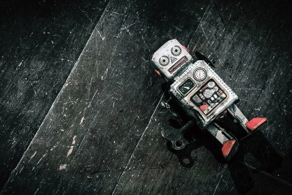 Sad beat up old retro robot on a wooden floor — Stock Photo, Image