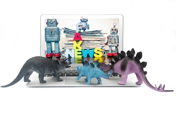 Brinquedos de dinossauro assistir notícias falsas — Fotografia de Stock