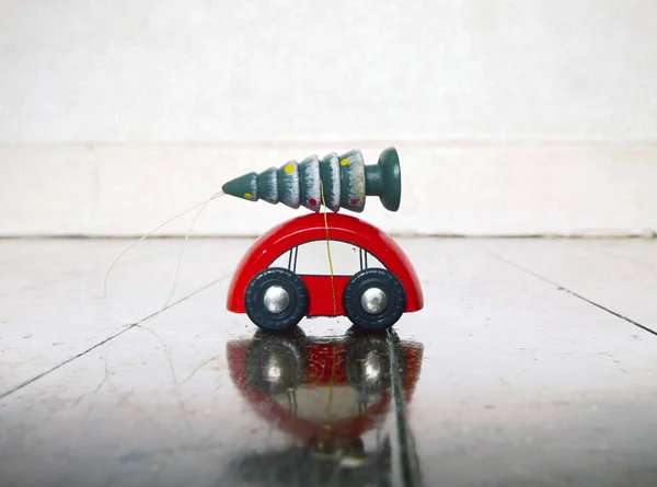 Pequeno carro de brinquedo de madeira vermelho com uma árvore de Chrismas — Fotografia de Stock