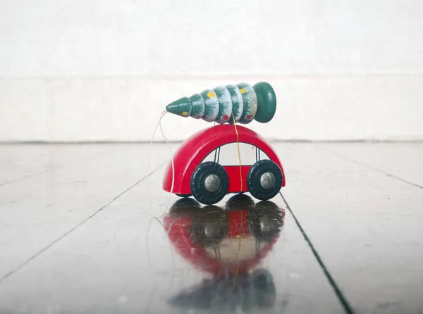 Piccola macchina giocattolo in legno rosso con un albero di Natale — Foto Stock