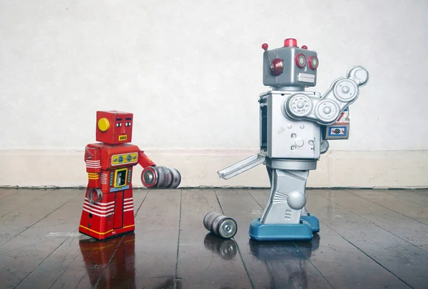 Red robot helping big silver robot — Stock Photo, Image