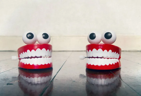 Dois platic dentes brinquedos conversando em um velho chão de madeira — Fotografia de Stock