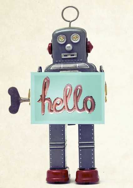 grey retro robot holding a hello sign