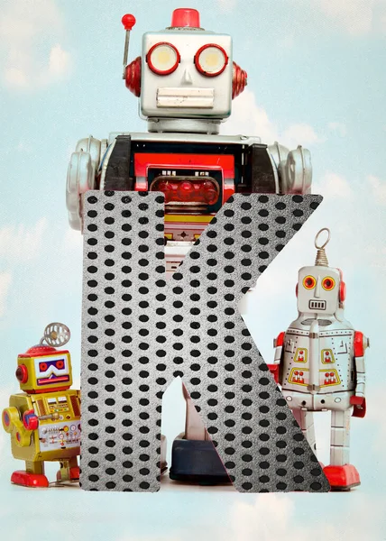 Retro Robot Juguetes Sosteniendo Una Gran Letra —  Fotos de Stock