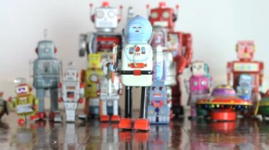 Eski oyuncak robot tahta zeminde yürüyor. 