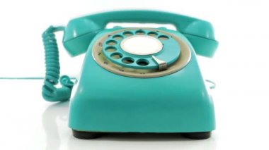 Beyazlar üzerinde izole edilmiş bir şekilde çalan eski bir turkuaz telefon.